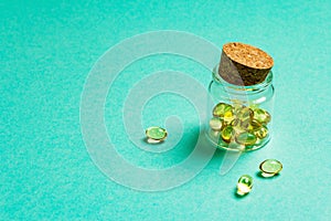 Omega-3 tablets in an old bottle on a turquoise matte background