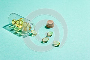 Omega-3 tablets in an old bottle on a turquoise matte background