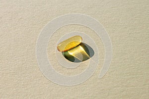 Omega-3 capsule, fish oil on a gray background, sharp shadow