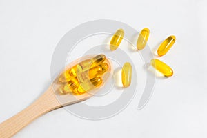 Omega 3 vitamins on a wooden spoon on a white background