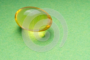 omega3 pill on a green background. close up. health