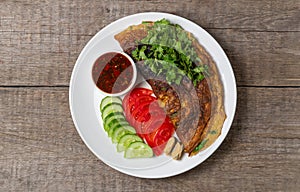 Omelet with mussels. Popular Thai food served with fresh vegetables and sauce on a plate. The view from the top. Copy-space.