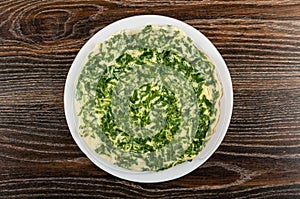 Omelet with parsley in white plate on wooden table. Top view