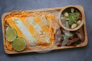 Omelet rice served in wooden plate on cement background