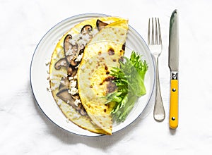 Omelet with shiitake and eringi mushrooms - delicious, healthy, vegetarian brunch on a light background, top view