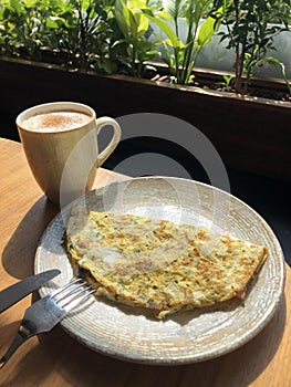 Omelet with vegetables and bacon and coffee latte with cinnamon