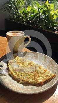 Omelet with vegetables and bacon and coffee latte with cinnamon