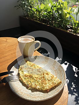 Omelet with vegetables and bacon and coffee latte with cinnamon