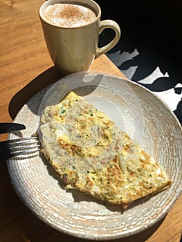 Omelet with vegetables and bacon and coffee latte with cinnamon