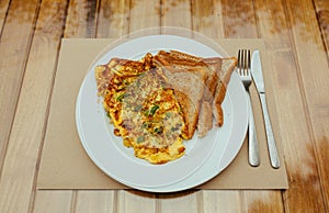 Omelet with vegetables and bread toast on white a plate