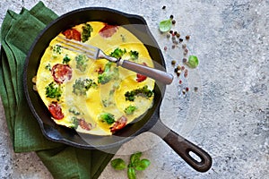 Omelet with vegetables in a cast-iron pan