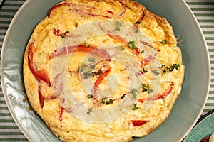 Omelette with red bell pepper on light wooden background. Healthy diet food for breakfast.