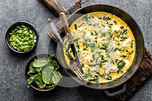 Omelette with spinach and cheese in a pan top view photo