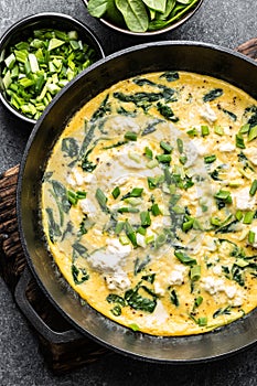 Omelette with spinach and cheese in a pan top view photo