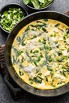 Omelette with spinach and cheese in a pan top view