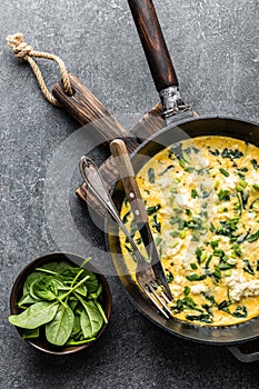 Omelette with spinach and cheese in a pan top view