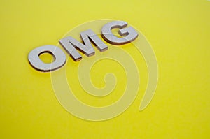 OMG wooden letters representing Oh My God on yellow background