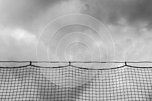 Ominous clouds viewed through baseball netting