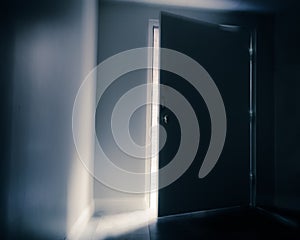 Ominous door slightly open with shaft of light