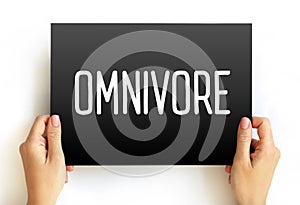 Omnivore is an organism that eats plants and animals, text concept on card photo