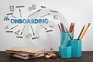 ONBOARDING. Office supplies and books on a wooden table photo