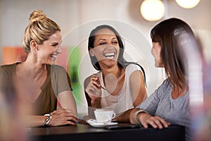 Once she got them laughing they couldnt stop. three women enjoying a conversation in a restaurant.