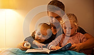 Once upon a time...A father reading a bedtime story to his kids.