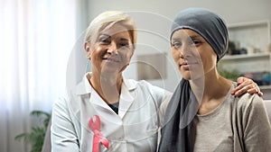 Oncologist and cancer patient looking into camera, hoping for healing survival