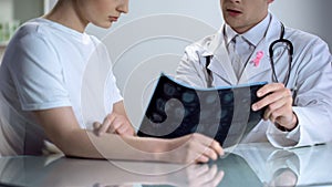 Oncologist consultation, doctor shows patient mammogram, breast cancer awareness