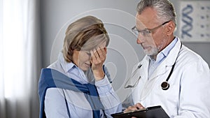 Oncologist informing upset lady about bad test results, cancer treatment photo