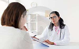 Doctor with pink awareness ribbon and patient