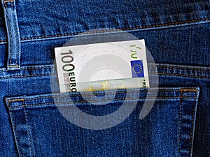 One 100 euro banknote in blue jeans pocket top view with copy space.