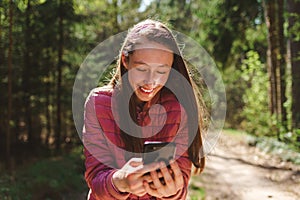 One 13s girl making a video call to her friend in the forest, Online communication concept.Nice sunny spring day