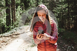 One 13s girl making a video call to her friend in the forest, Online communication concept.Nice sunny spring day