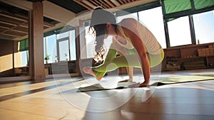 One 30s personal trainer doing asanas on matting in yogas studio