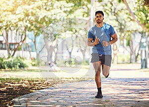 One active young indian man exercising outdoors. Handsome male athlete enjoying a jog or run for cardio training workout