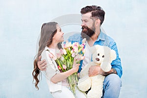 One adoption is enough to change lives. Adoptive family. Bearded man and little girl hold flowers and toy. Child