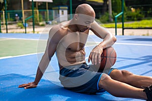 One african-american male basketball player playing at street public stadium, sport court or palyground outdoors