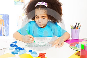 One African girl writing letters with pencil