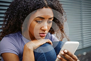 One alone black young woman holding mobile phone