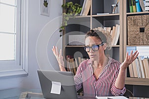 One alone unhappy and sad woman at home in the office using laptop and looking at it with hands in the head. Stressed female in