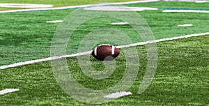 One American football on a green turf field