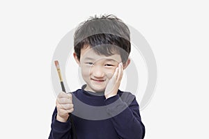 One asian boy child holds painting brush