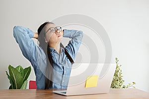 One Asian woman is working with laptop in office. She gets stressed from work and then she looks outside