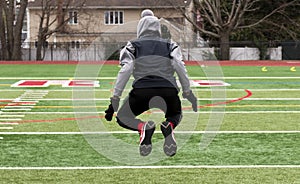 One athlete jumping in the air on a turf field