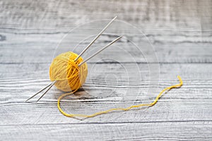 One ball of wool knitting needles on thewooden background