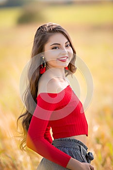 One beautiful female caucasian high school senior girl in red crop top sweater