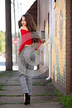 One beautiful female caucasian high school senior girl in red crop top sweater