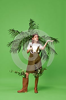 One beautiful little girl wearing rain boots standing and holding umbrella over green background. After the rain