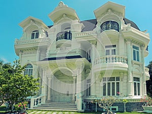 One beautiful three-story house with  trees, flowers and landscape design in the summer.